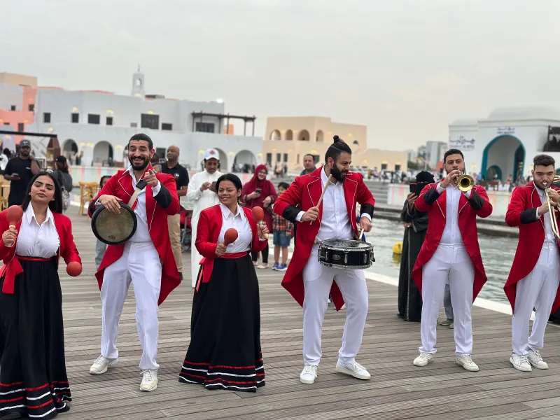 Marching band in red jackets performing on the Old Doha Port waterfront