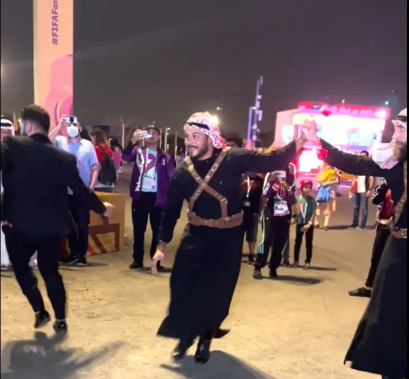 Folk dancer in traditional costume leading guests in a lively procession at night