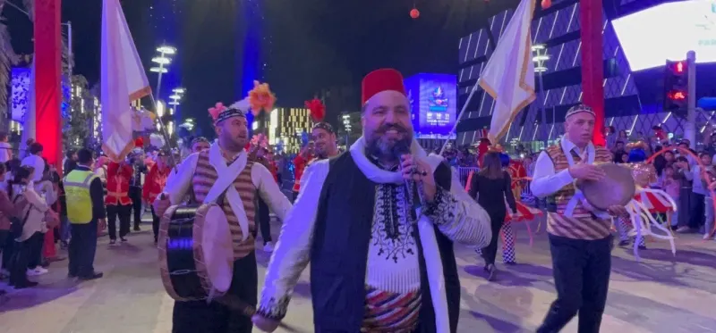 Drummers in traditional costumes leading a street parade along Lusail Boulevard