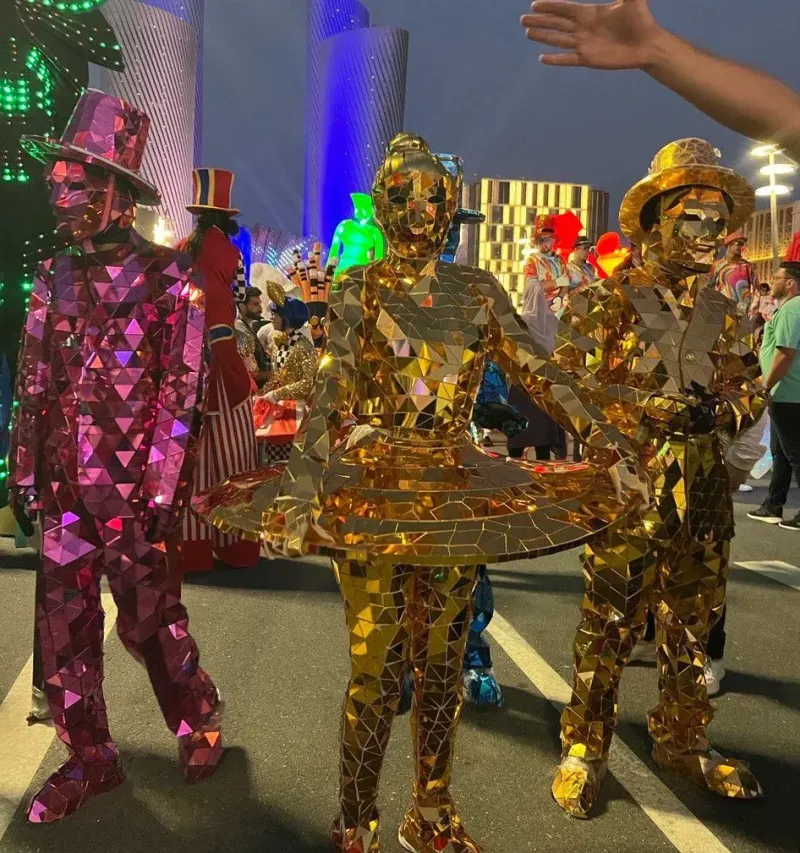 Performers in glittering mirrored costumes in a night street parade