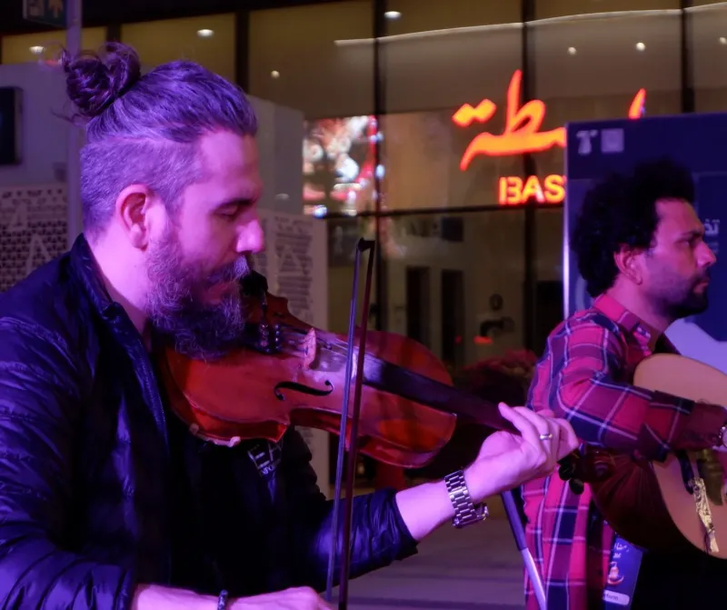 Violinist and guitarist performing live outdoors at Lusail Boulevard