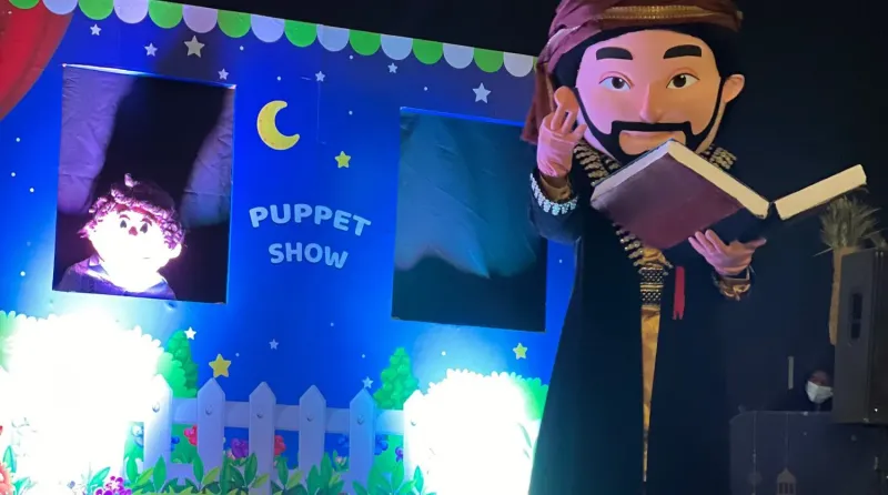 Puppet show stage with colourful backdrop and storyteller puppet in traditional dress