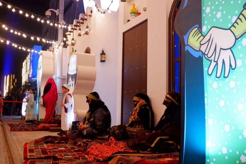 Traditional Ramadan house stage set with lanterns and performers seated on carpets
