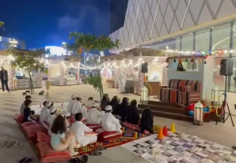 Evening Ramadan majlis seating area with cushions and families along the Lusail Boulevard promenade