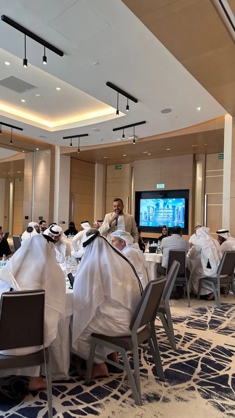 Guests seated in a hotel ballroom with a presentation screen at a team-building event