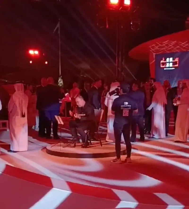 Guests gathering around a circular stage lit in red and white at a brand launch