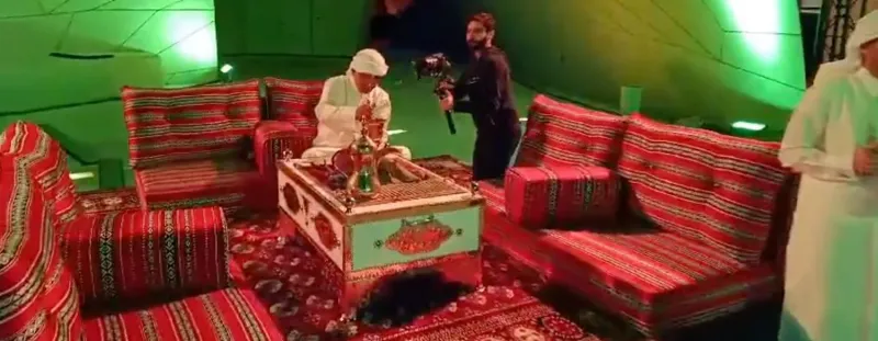 Traditional majlis seating with a performer under green lighting at a brand launch
