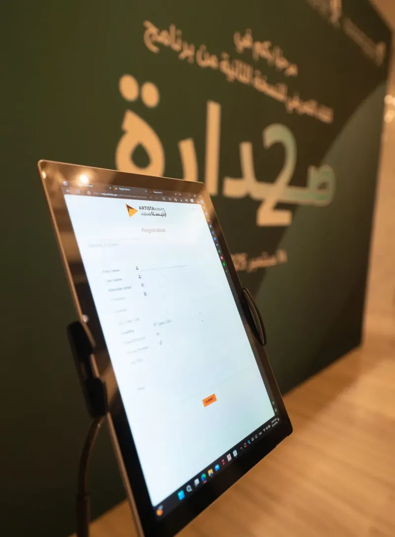 Tablet showing a registration screen beside the Sadara 2 branded backdrop