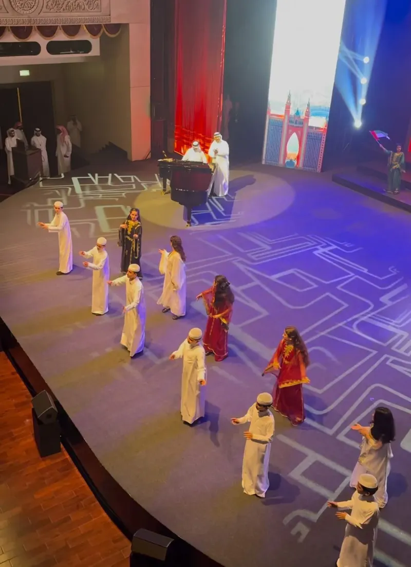 Wide view of the operetta cast performing on a stage with illuminated floor patterns
