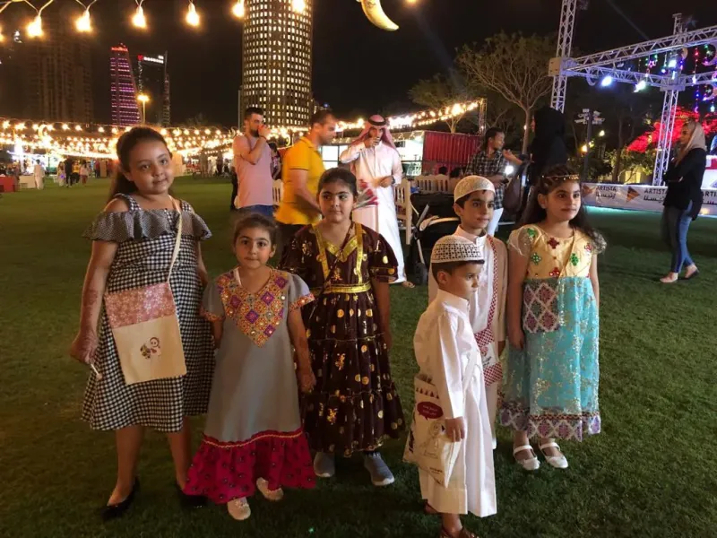 Children in traditional Qatari dress posing at the Tehlaya Ramadan festival