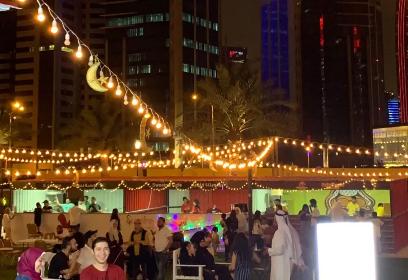 String lights and crescent decorations above festival stalls in Doha at night